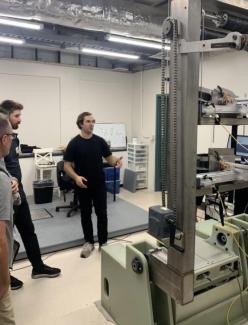 three people in front of mechanical equipment in a lab